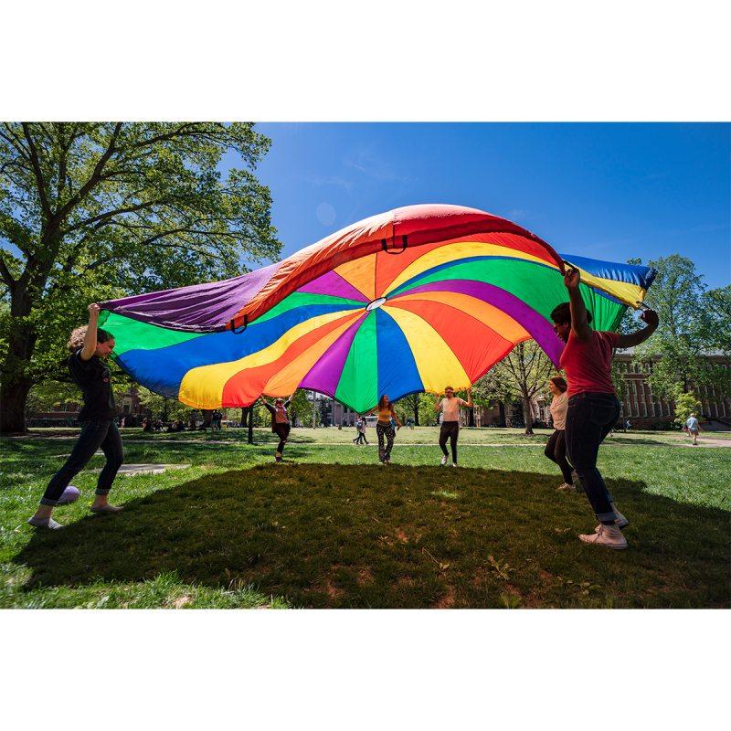 Group of people with rainbow-colored tarp